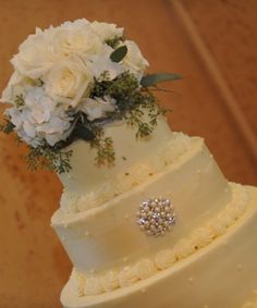 a three tiered wedding cake with white flowers on top