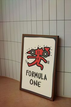 a sign that says formula one on the side of a wall with tiles behind it