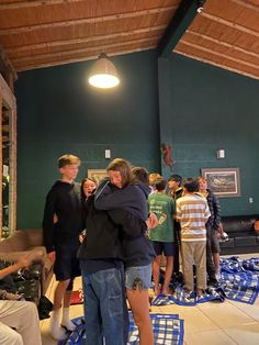 a group of people standing around each other in a room with blue rugs on the floor