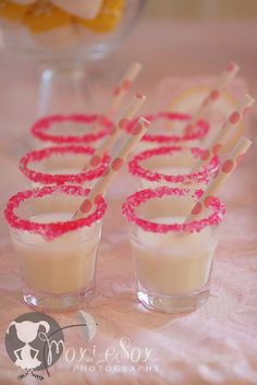 small glasses with straws in them sitting on a table