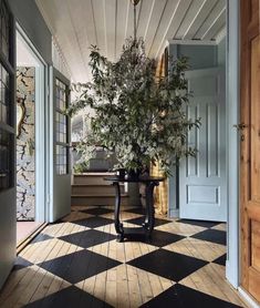 a room with a checkered floor and potted plant