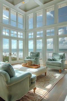 a living room filled with furniture and large windows overlooking the ocean on a sunny day