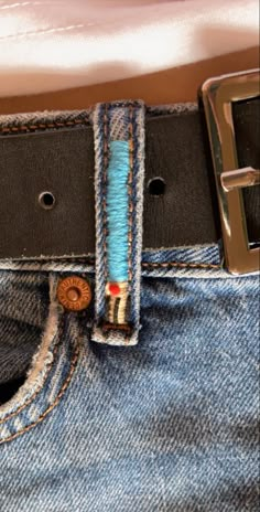 there is a belt with buttons on it in the pocket of someone's jeans