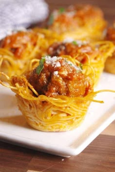 some spaghetti and meatballs are on a white plate