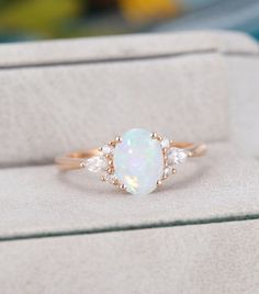 an opal and diamond ring in a box