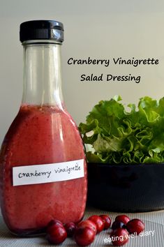 cranberry vinaigrete salad dressing in a glass bottle next to fresh lettuce