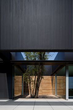 the entrance to an empty building with large windows and wooden paneling on the outside