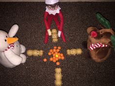 two stuffed animals and an elf on the floor