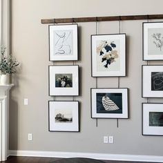 a living room with pictures hanging on the wall and a fireplace in front of it