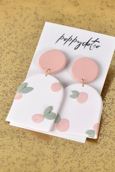 two pink and white polka dot earrings on top of a card with the words happy birthday to you