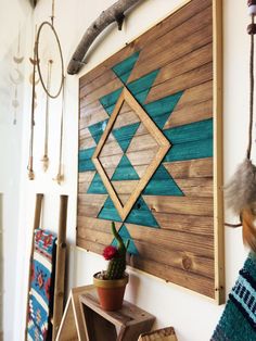 a wooden wall hanging next to a potted cactus