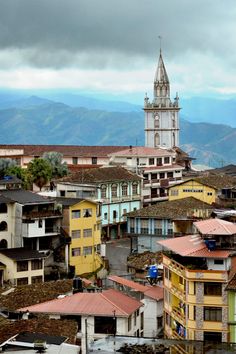 a view of a city with buildings and a clock tower in the distance on a cloudy day