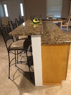 a kitchen island with chairs around it