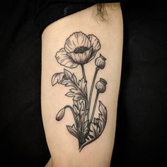 a black and white photo of some flowers on the right side of the arm,