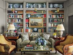 a living room filled with furniture and bookshelves covered in lots of bookcases