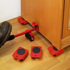 a pair of red feet with black pads on them sitting in front of a wooden cabinet