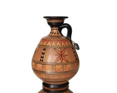 a brown and black vase sitting on top of a table