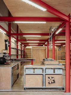 an empty room with red beams and shelves