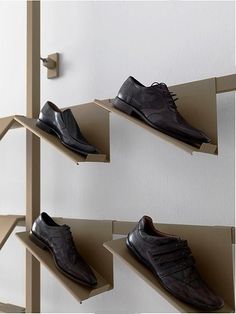 four pairs of shoes are hanging on the wall and one pair is in a shoe rack