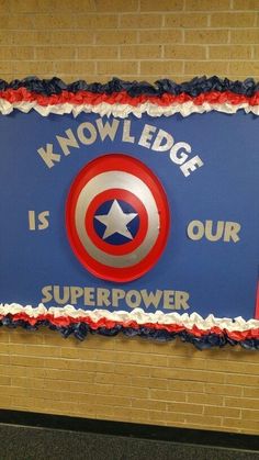 a cake decorated with the captain's shield is displayed on a wall in front of a brick wall