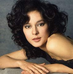 a close up of a person laying on a table with her hand on her chest