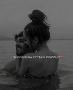 a man and woman in the water with a red heart on their chest that says, you are a rainbow in my black and white life