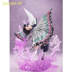 a figurine is posed as a fairy with wings and purple flowers on her body