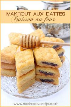 several pieces of cake sitting on top of a glass plate next to a honey stick