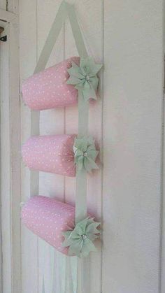 a pink and green wall hanging decoration with bows on the top, along with polka dots