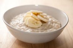 a white bowl filled with oatmeal and sliced bananas