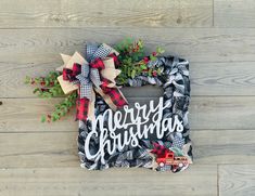 a christmas wreath with the words merry christmas hanging on a wooden wall next to a toy truck