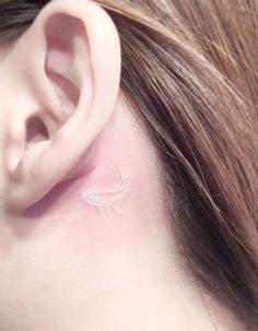 a close up of a person's ear with a small tattoo on it