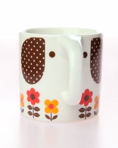 a coffee mug with an elephant design on the side and flowers painted on the inside