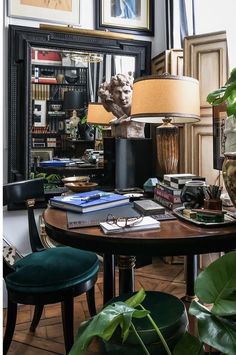 a living room filled with lots of furniture and art on top of a wooden table