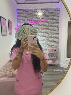 a woman taking a selfie in front of a mirror with money on her head