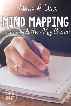 someone writing on a notebook with the words how use mind map to declutter my brain