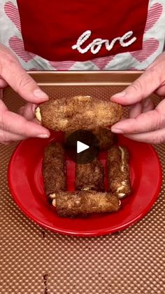 two hands holding doughnuts on a red plate