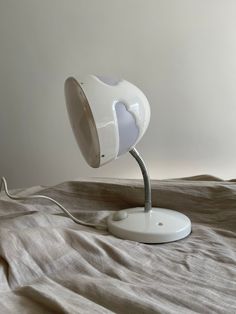 a white table lamp sitting on top of a bed