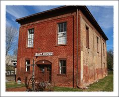 an old red brick building with a wagon in front and the words state house painted on it