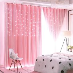 a bedroom decorated in pink and white with polka dots on the bed, window curtains, and chair