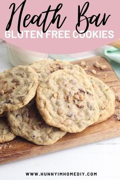 a pile of cookies sitting on top of a wooden cutting board next to a glass of milk