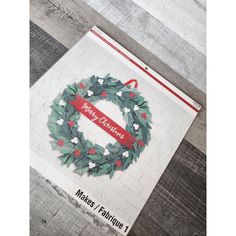 a handmade christmas card with a wreath and ribbon on the front that says merry christmas