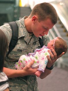 a soldier holding a baby in his arms