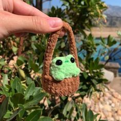 a hand holding a small stuffed toy in the shape of a bag