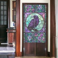 a stained glass door with a bird in the center and purple flowers on the side