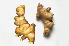 two ginger root pieces on a white surface