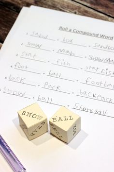 two dices sitting on top of a piece of paper next to a pen and pencil