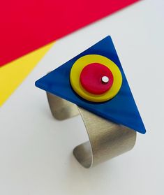 Bauhaus plastic aluminum geometric statement bracelet. Yellow, red and blue plexiglass pieces are attached to an aluminum cuff bracelet using a stainless steel micro-screw as a cold connection. No glue is used. The cuff bracelet measures 1 inch in width and 6 inches from end to end with a .75 inch opening. This fits a medium sized wrist. Please measure your wrist before ordering. Inspired by the Bauhaus movement and abstract artists Mondrian and Kandinsky, my goal is to create a piece of art to wear. Pair this with a coordinating brooch and earrings (see separate listings) for a total look. Bauhaus Movement, The Bauhaus, Modernist Jewelry, Total Look, Statement Bracelet, Abstract Artists, Cuff Bracelet, Favorite Jewelry, 6 Inches