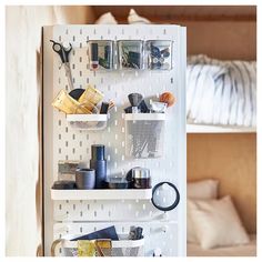 a white refrigerator freezer sitting inside of a kitchen next to a bed and pillows