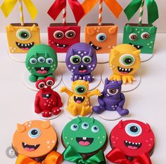 there are many different colored monsters on the table with candy sticks in their mouths and eyes